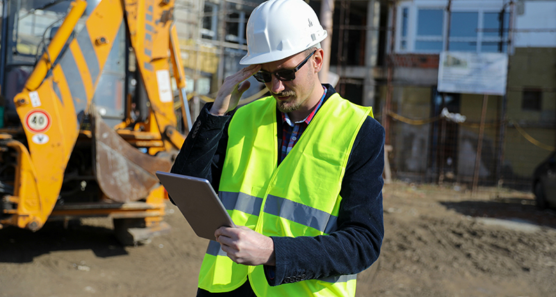 Construction worker onsite looking at tablet